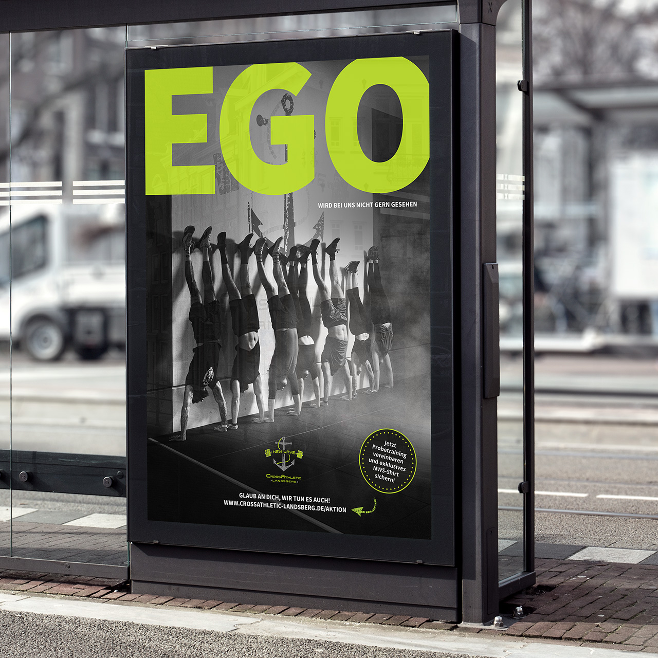 Mockup einer Anzeige an einer Bushaltestelle. auf welchem sieben Menschen zu sehen sind, die einen Handstand machen. Die Überschrift lautet: Ego wird bei uns nicht gern gesehen.